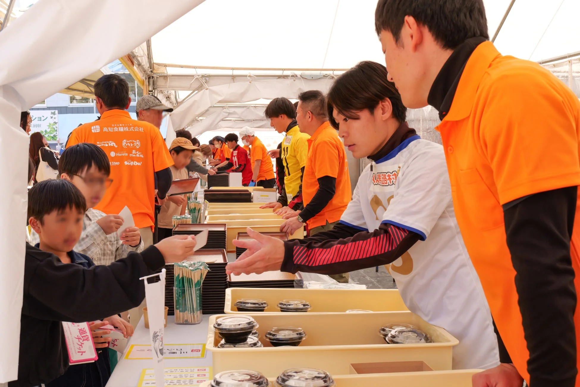 スタッフが子供たちに食事を配る様子