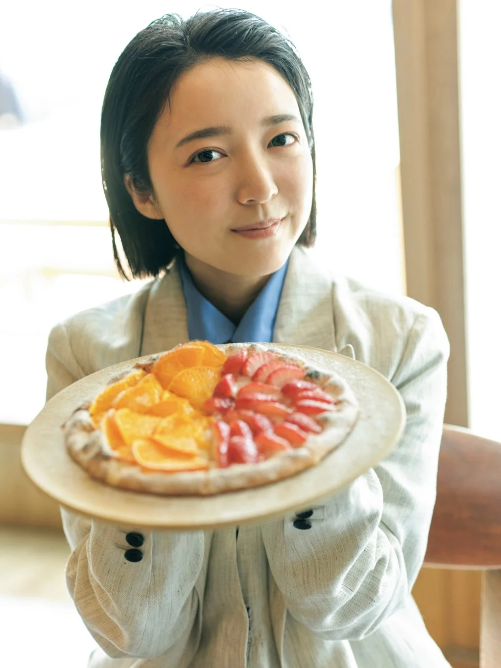上白石萌音さんがフルーツタルトを差し出している笑顔のポートレート
