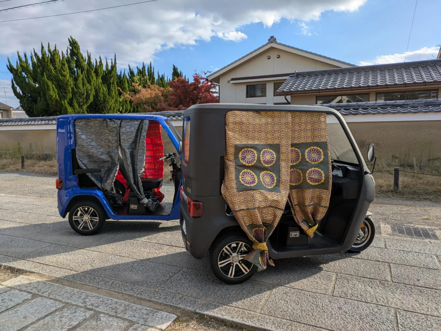 伝統家屋背景の電動三輪車