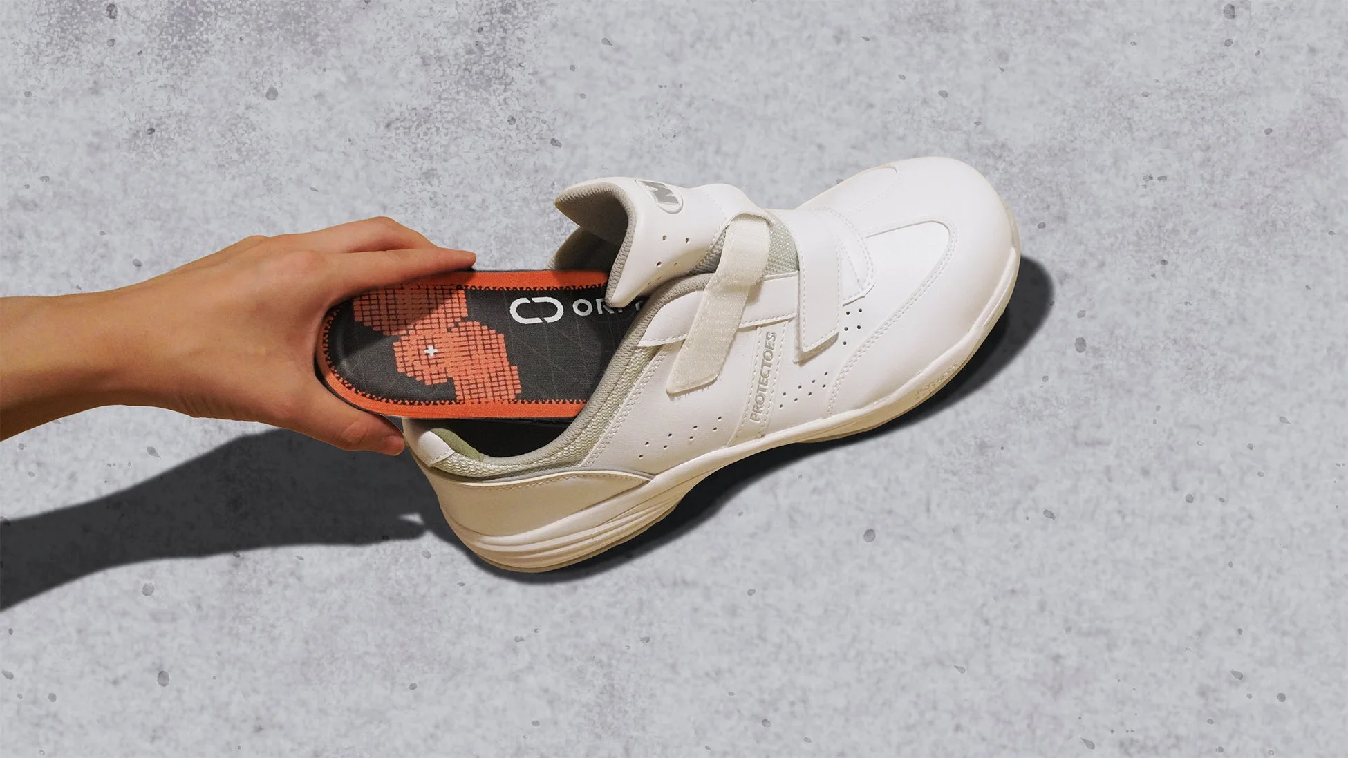 靴にインソールを差し込む様子