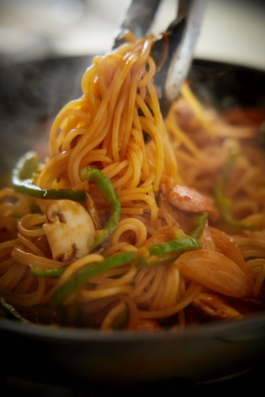 スパゲッティをトングで持ち上げる様子