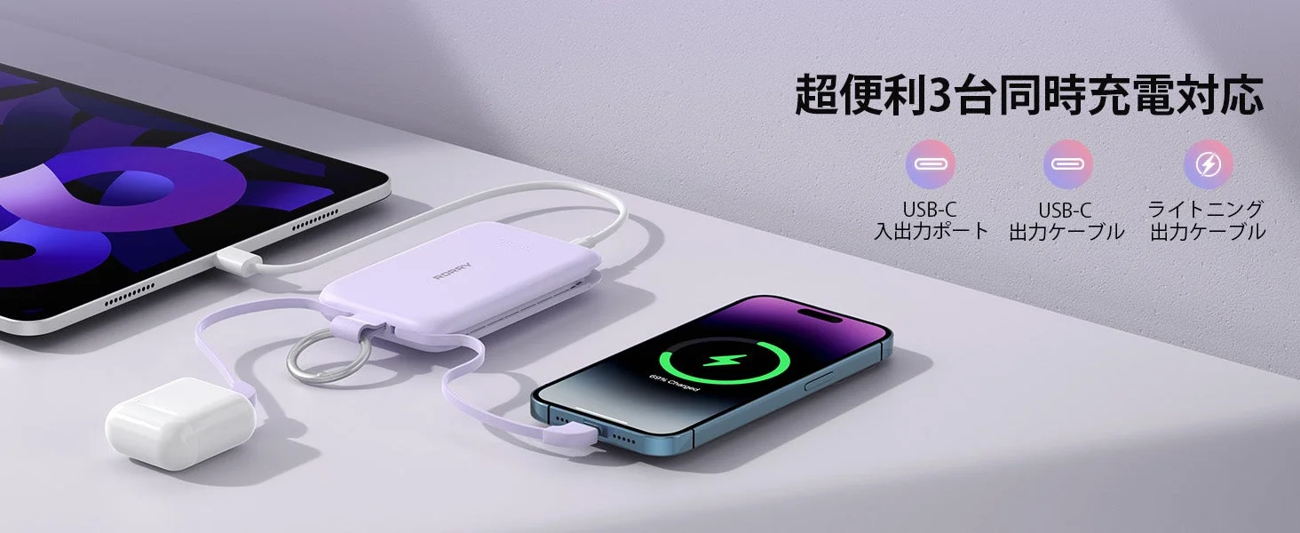 紫色のモバイルバッテリーが、タブレット、スマートフォン、ワイヤレスイヤホンを同時に充電している様子。3台同時充電に対応しており、USB-Cとライトニングケーブルが利用できることを示しています。