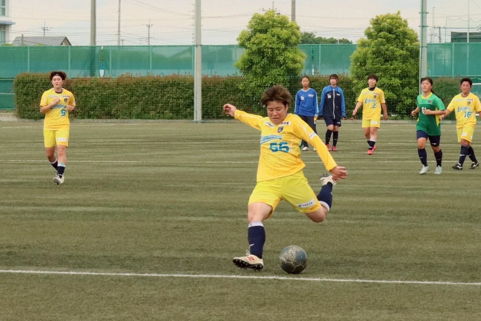 人工芝でボールを蹴る女子サッカー選手