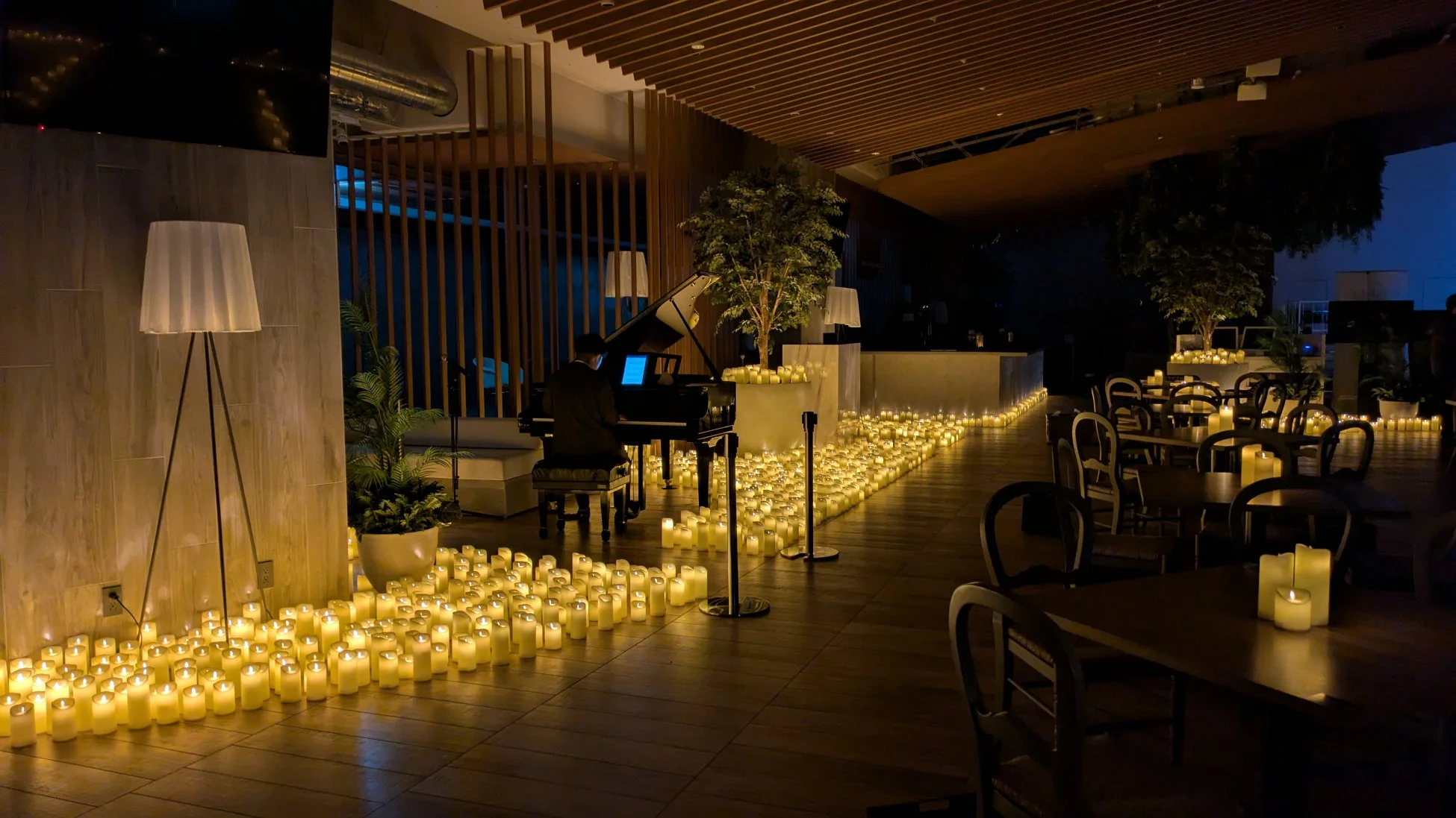 キャンドルに囲まれたロマンチックな空間でピアノの生演奏が行われている様子