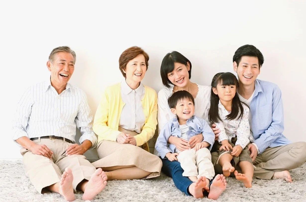 笑顔で座る三世代の家族