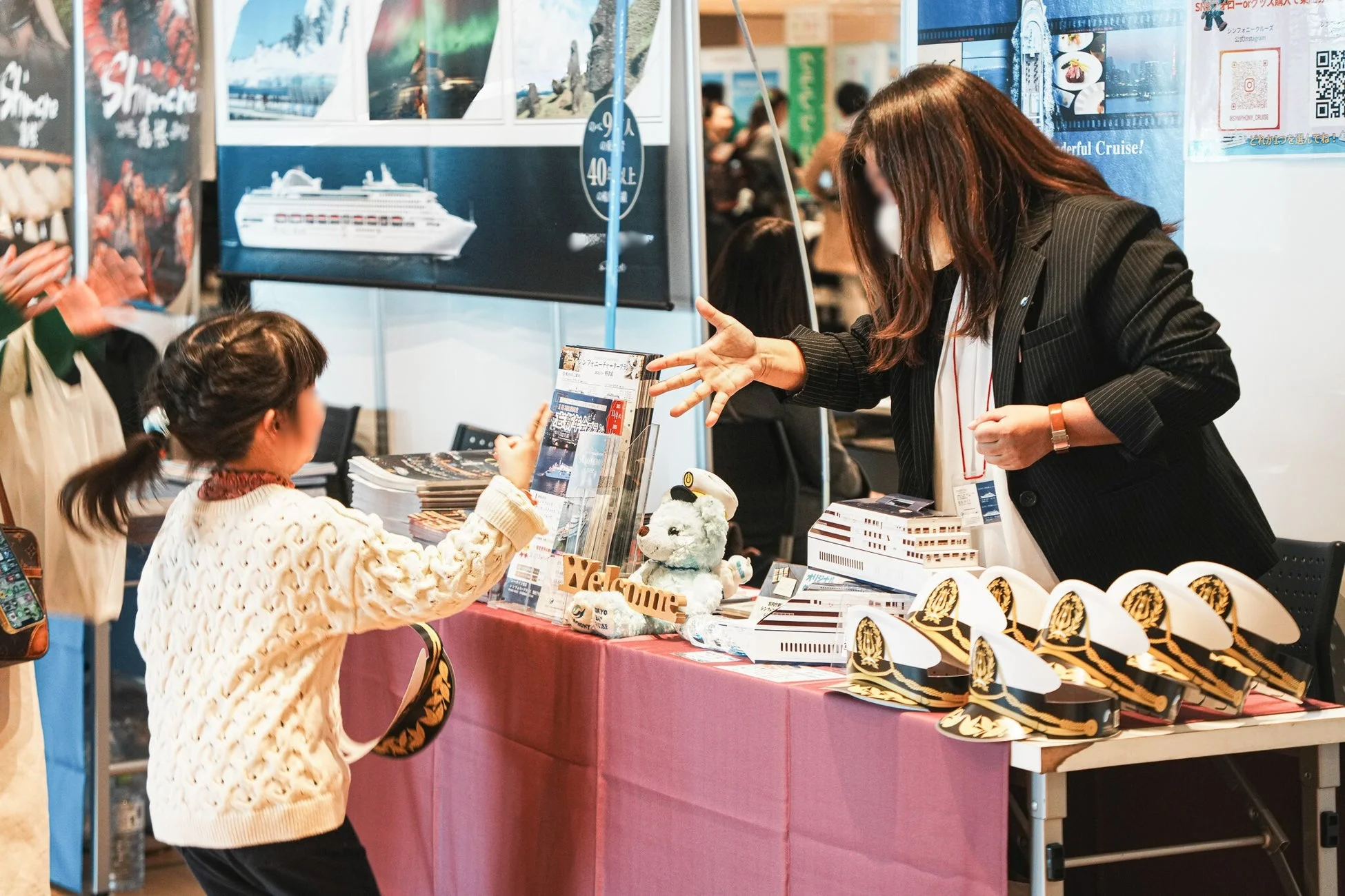 ブースで子供に説明するスタッフ