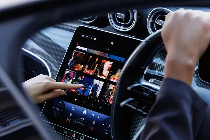 運転手が大型のタッチスクリーン式インフォテインメントシステムを操作している様子