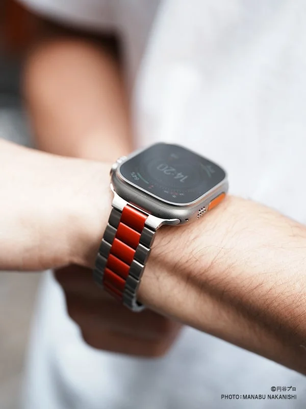 赤とシルバーのメタルバンドのスマートウォッチ