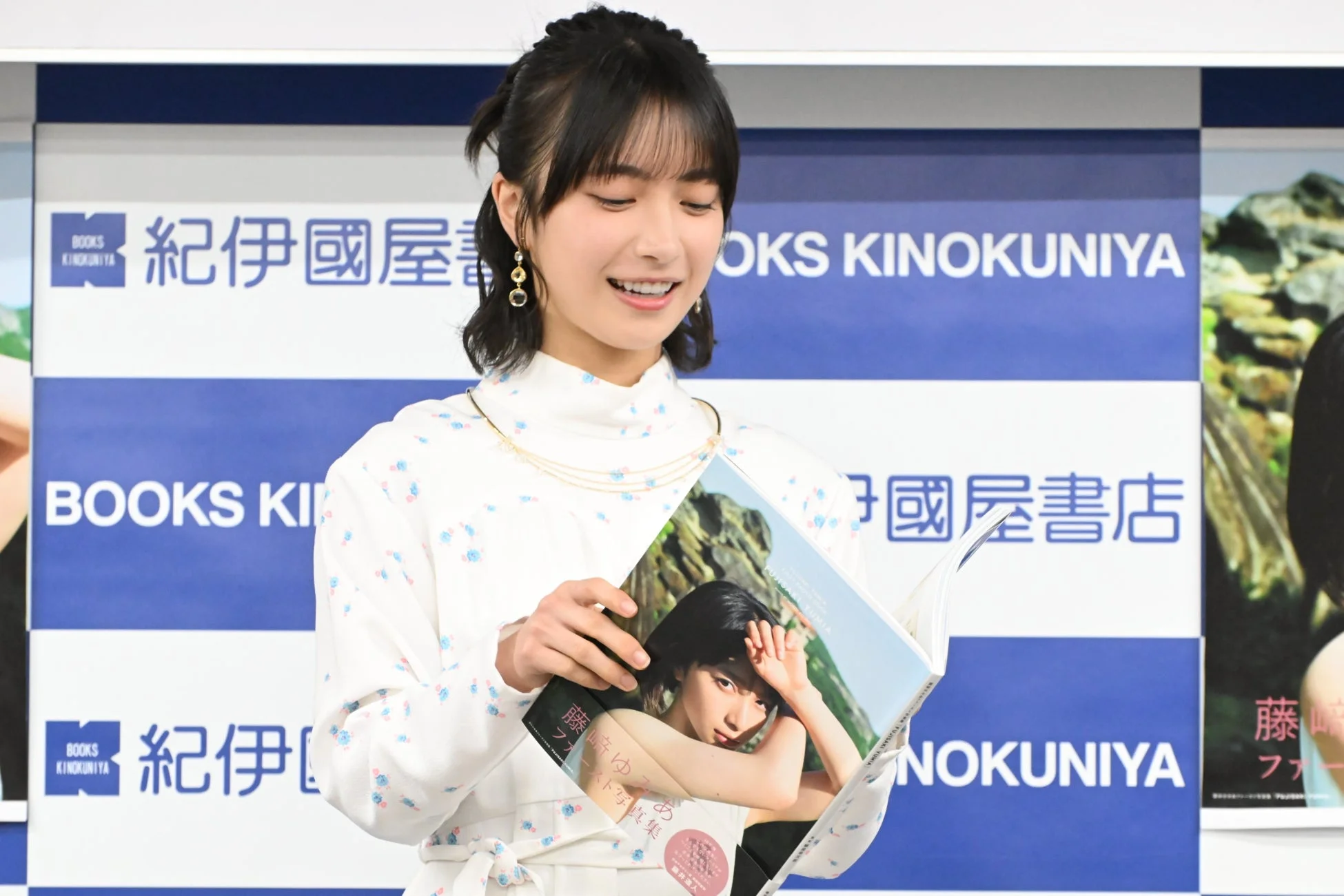 写真集を手に持つ藤﨑ゆみあさん