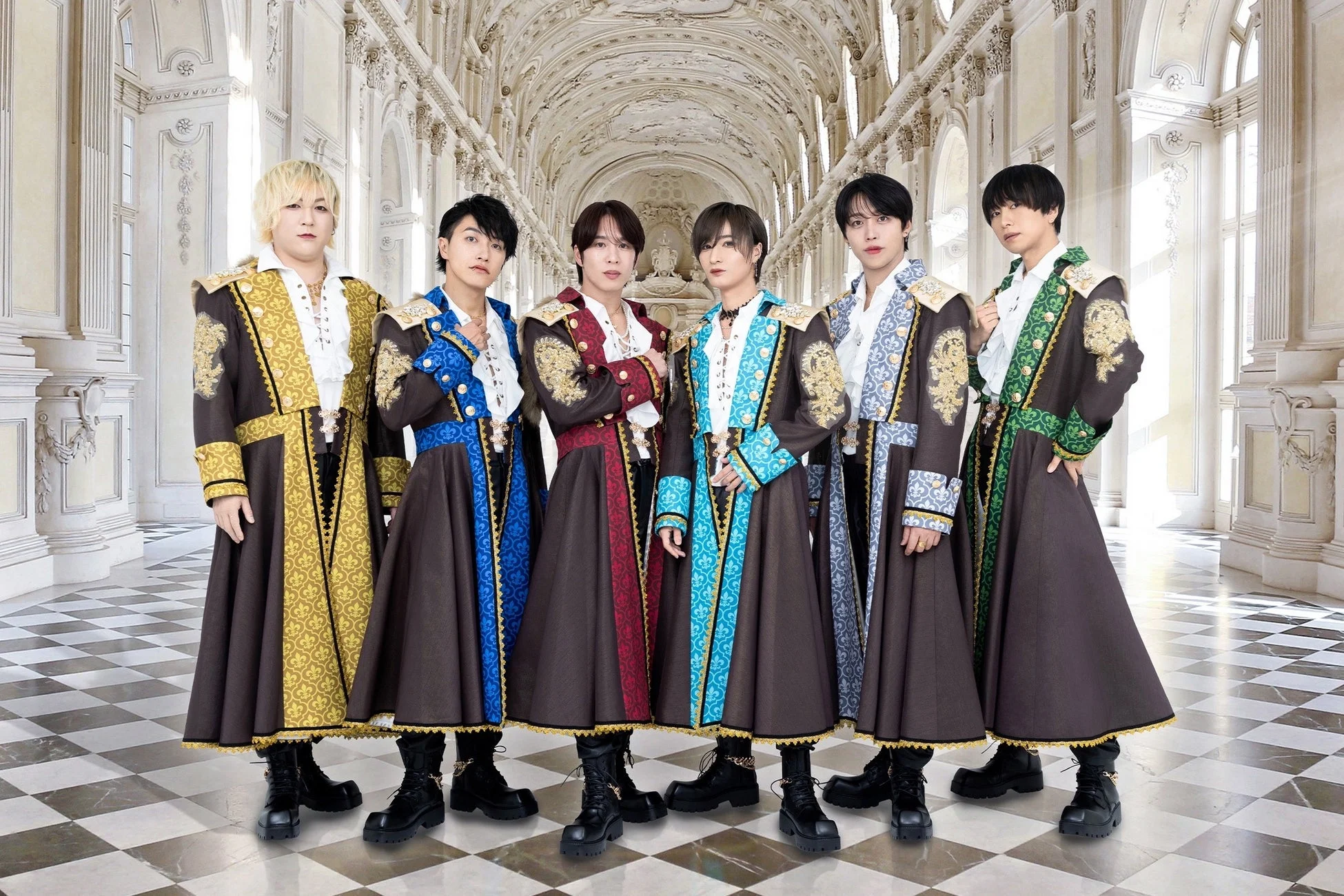 豪華な装飾が施された宮殿のような空間で、貴族風の華やかな衣装をまとった6人の男性グループ