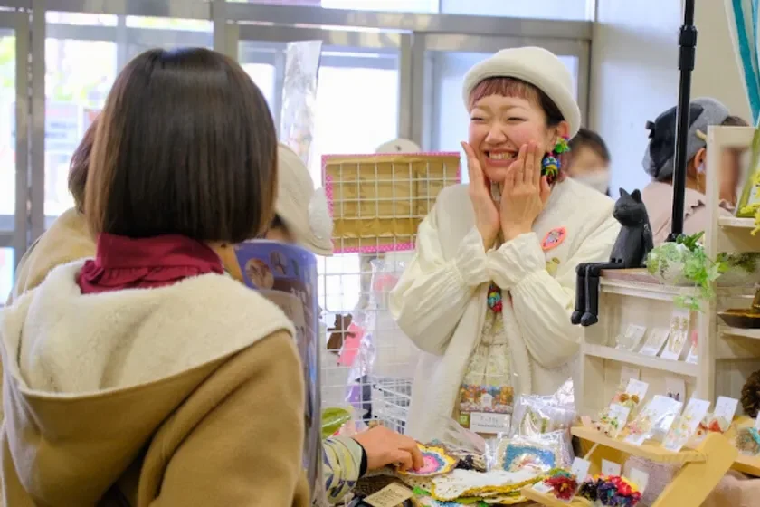 クラフトマーケットで笑顔で話す女性