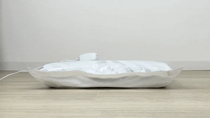 真空圧縮袋で衣類を圧縮する様子