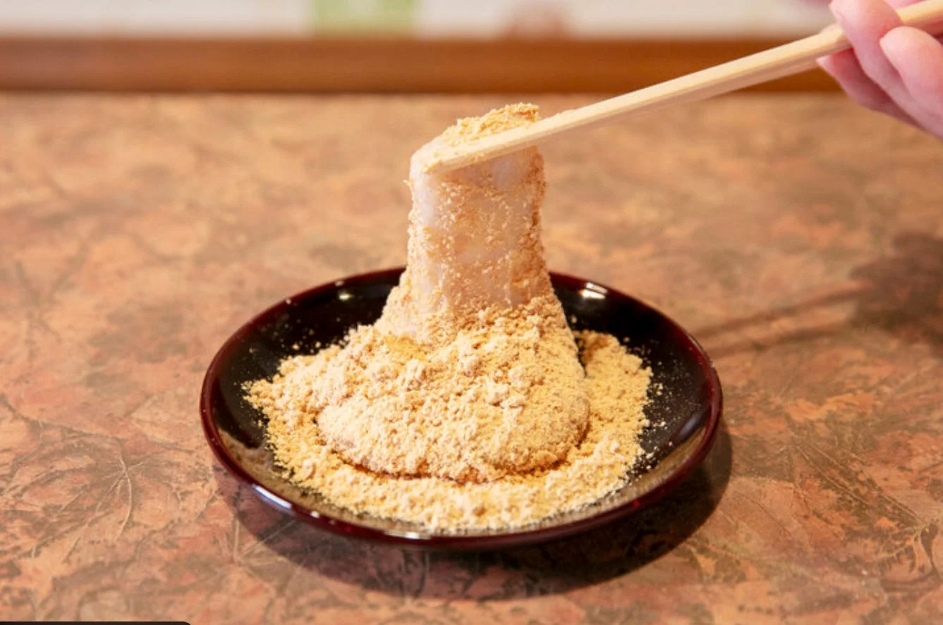 きな粉がたっぷりの和菓子を箸でつまんでいる様子