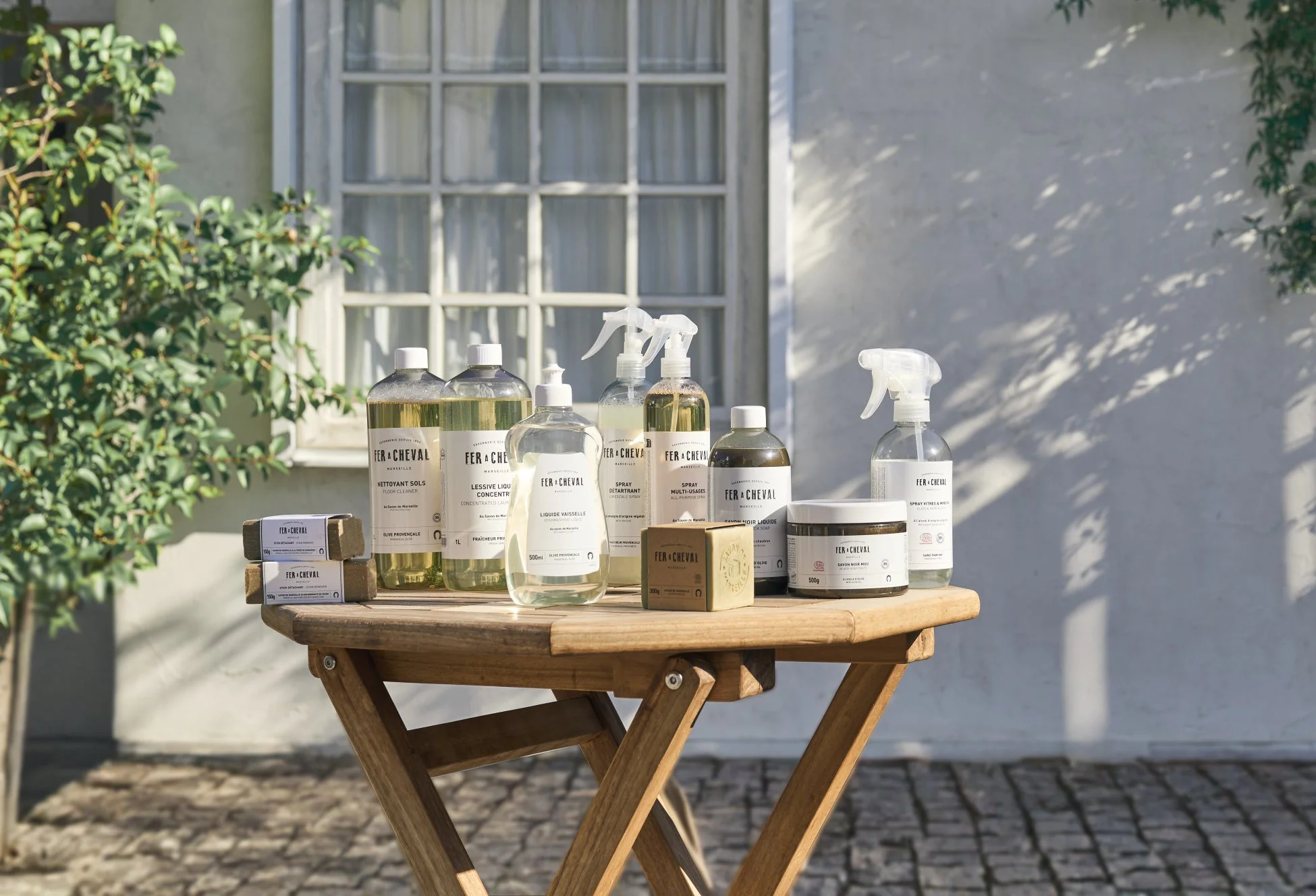 FER+CHEVALの様々な家庭用洗剤と石鹸が並べられた木製テーブル