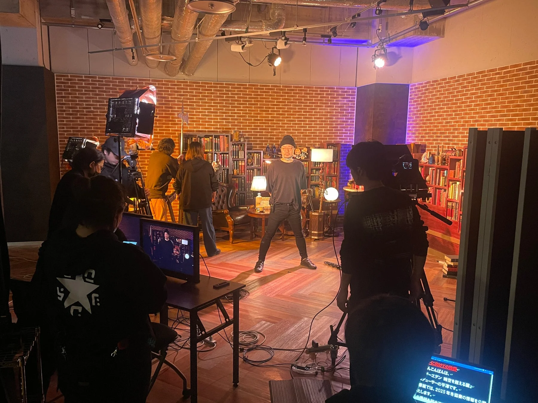 スタジオのレンガ壁の前で撮影している様子
