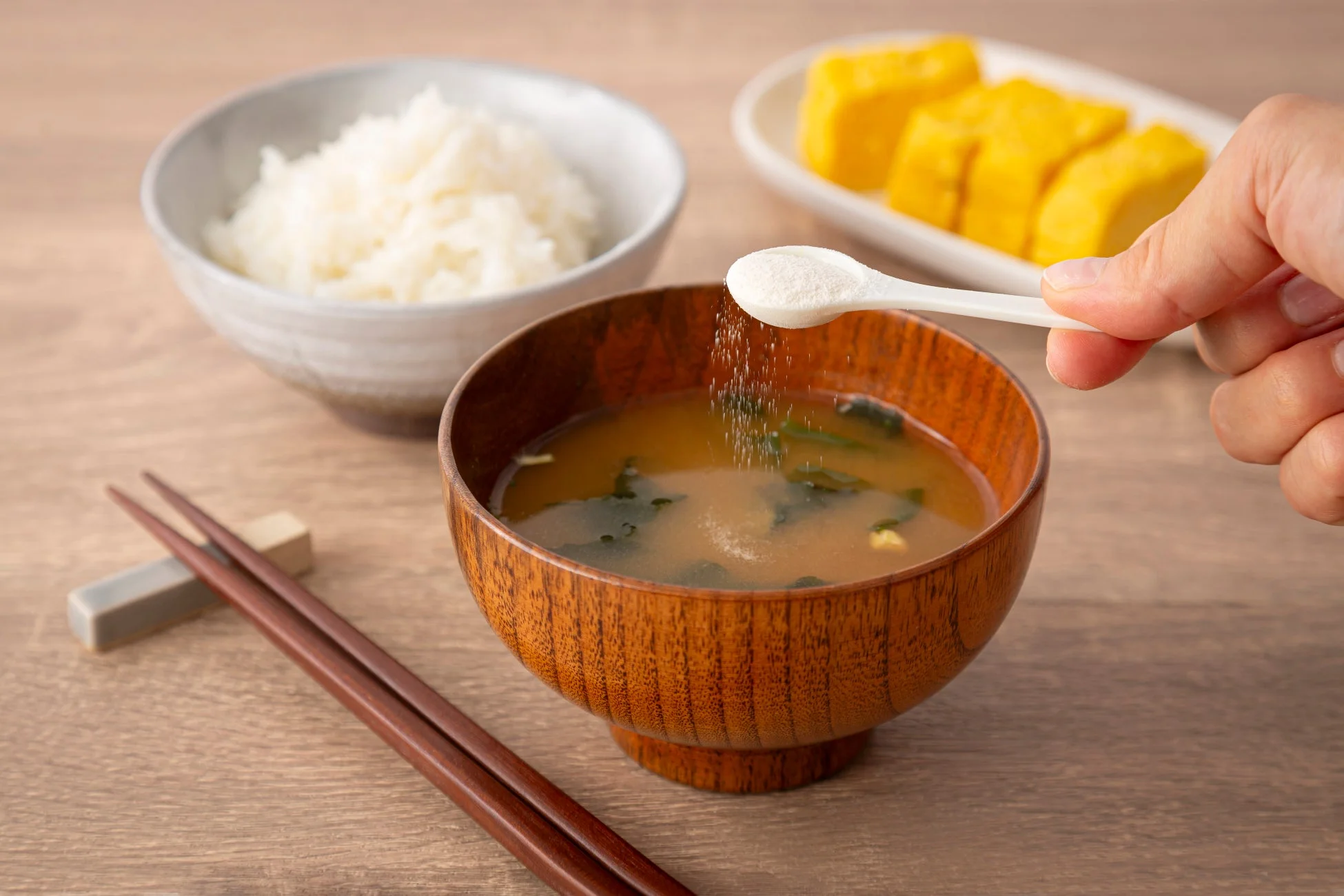 味噌汁に白いパウダーを加える様子