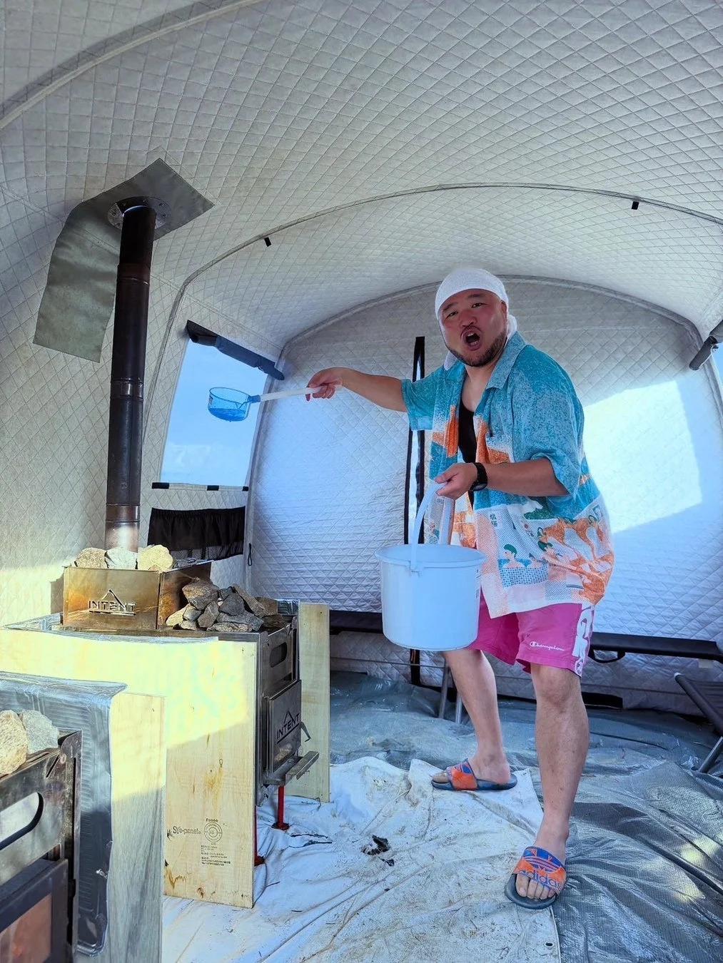 テントサウナの中でロウリュをする男性