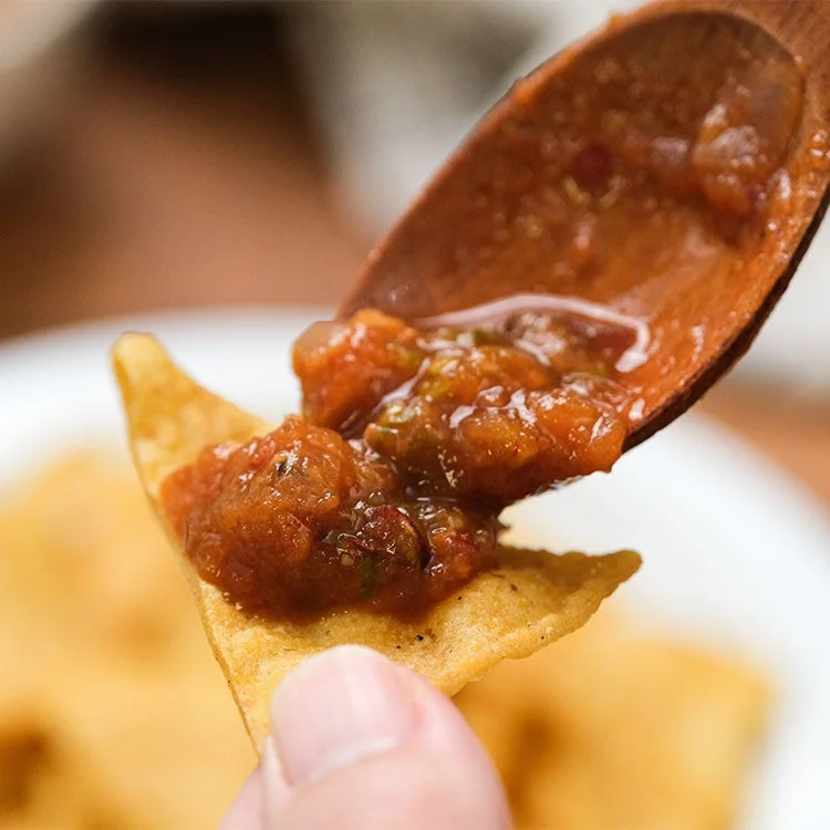 トルティーヤチップスにサルサを乗せる様子