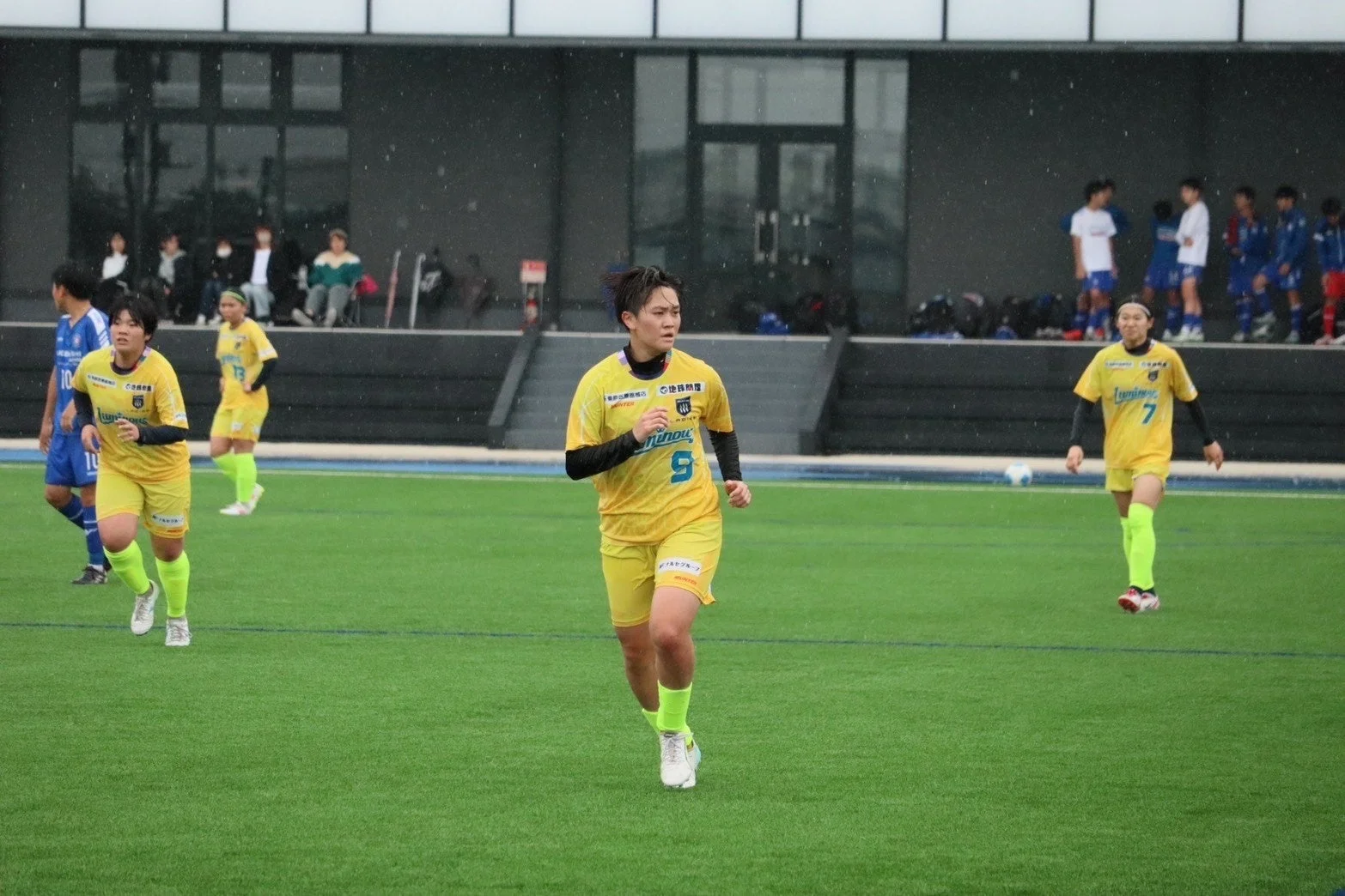 雨の中でサッカーをする女子選手たち