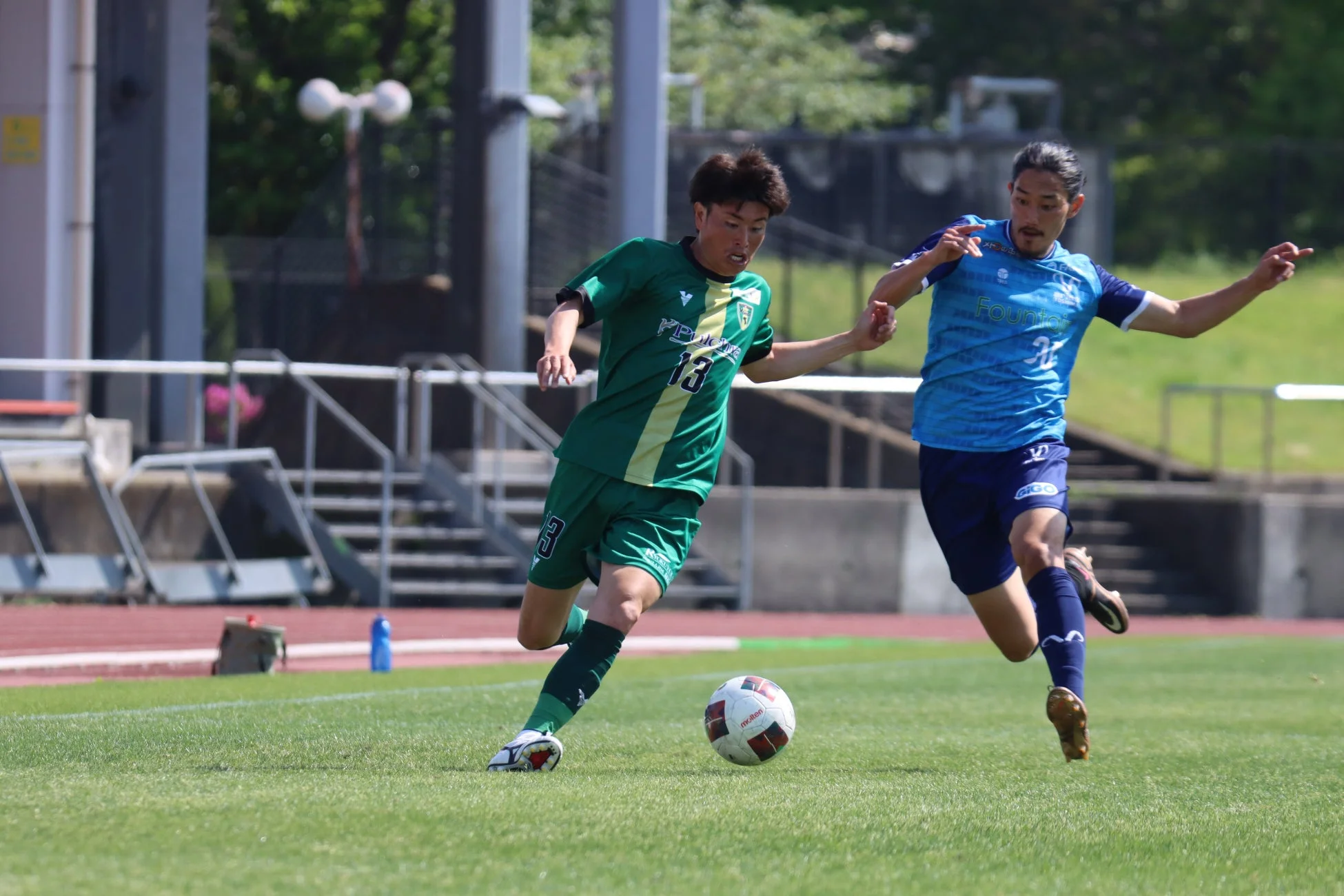 サッカーの試合中、ボールをドリブルする選手