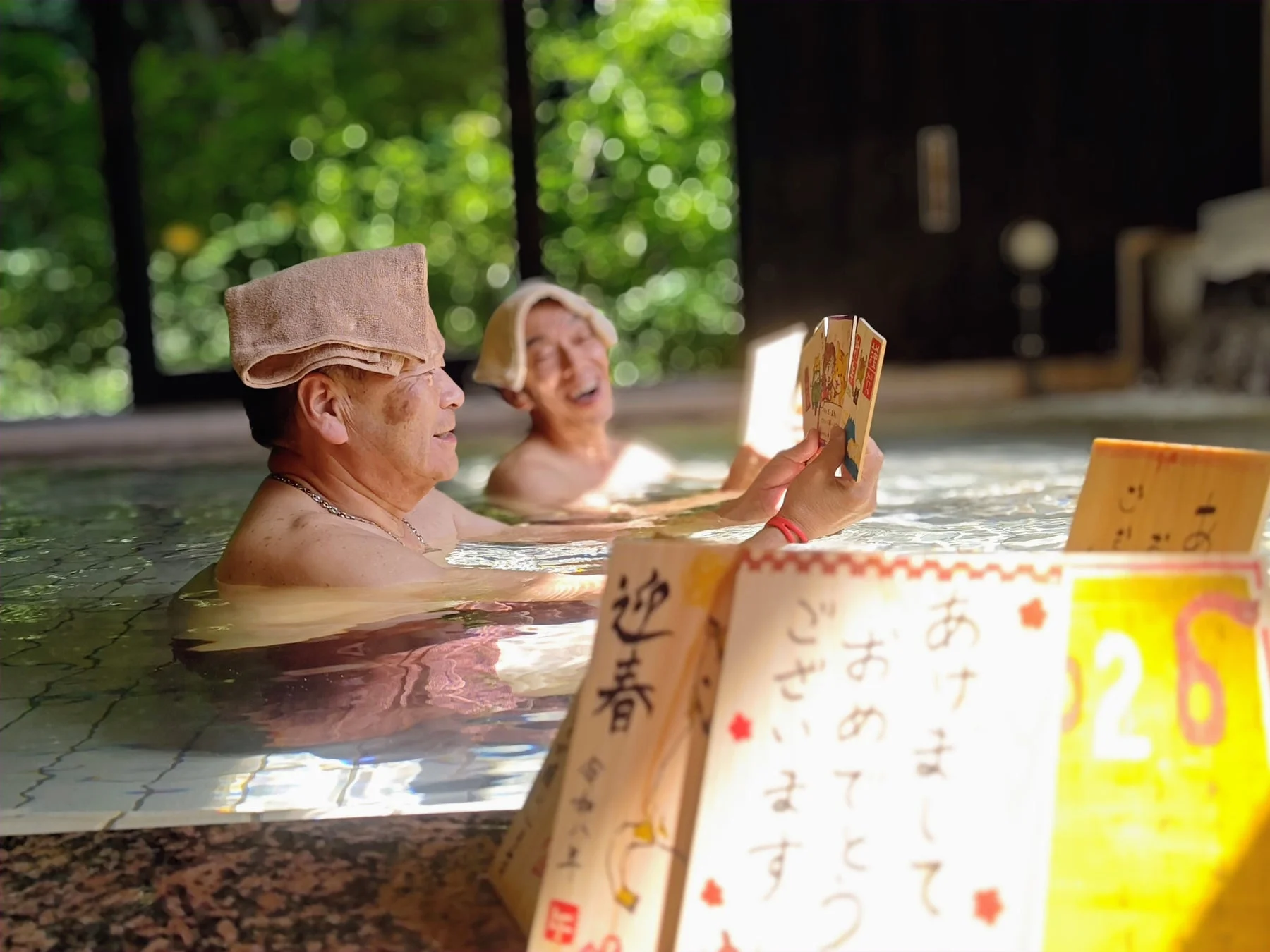 温泉に浮かぶ年賀状型の木札