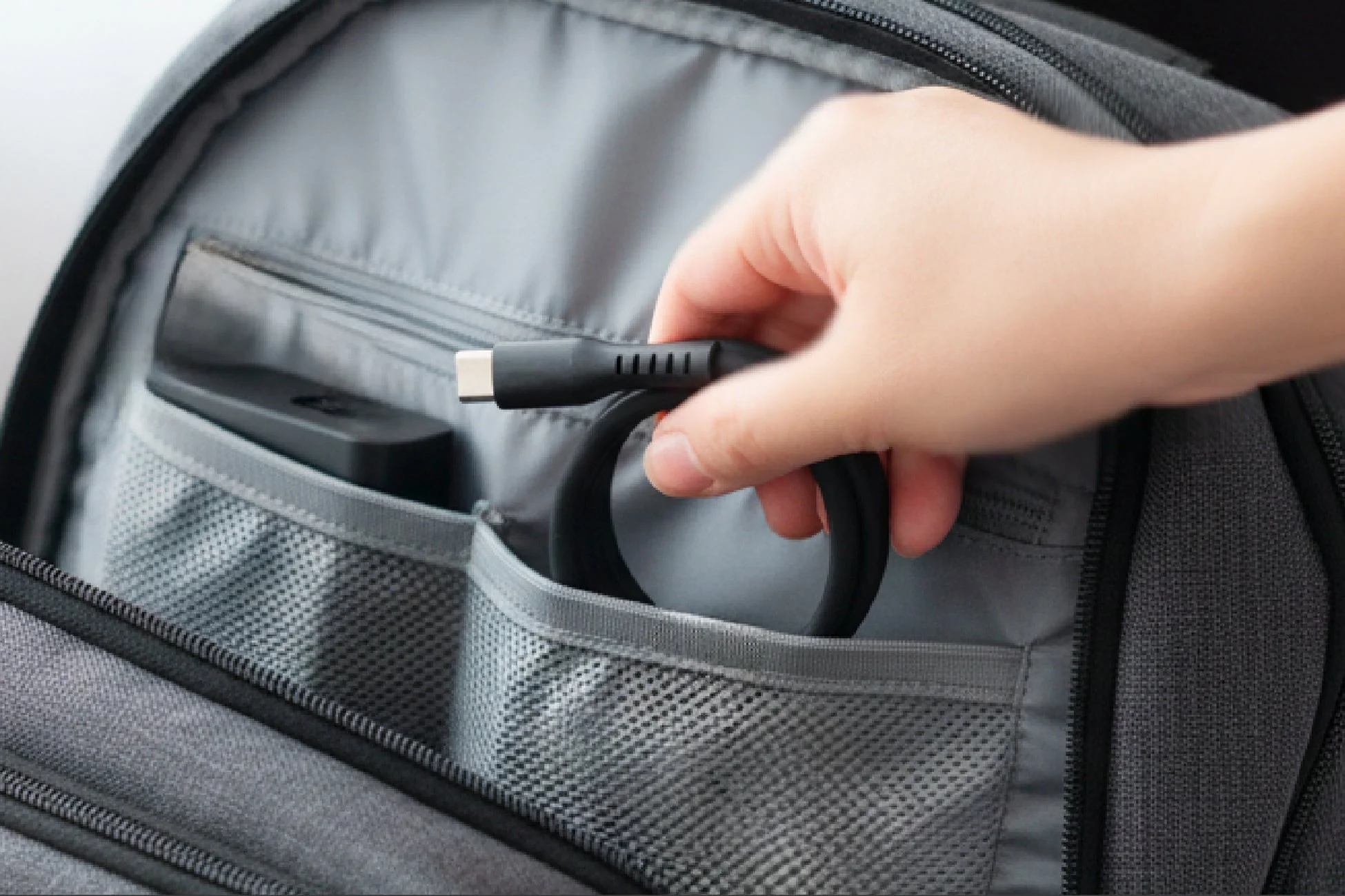 リュックからケーブルを取り出す様子