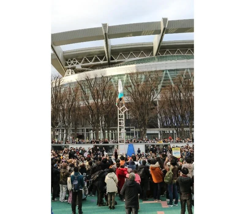 複数の椅子の上で倒立するパフォーマー