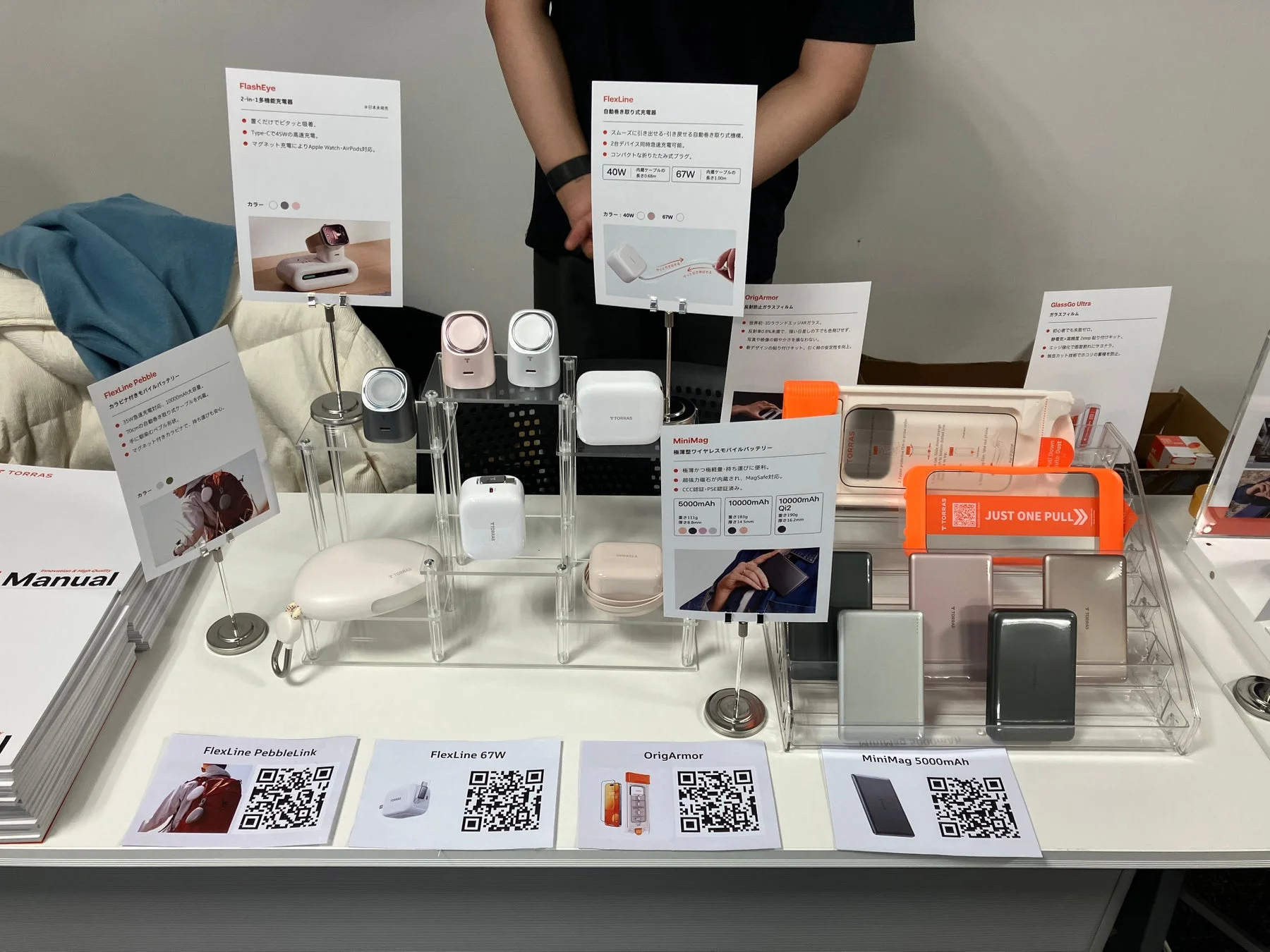 TORRASブランドの多機能充電器、自動巻き取り式充電器、モバイルバッテリー、ガラスフィルムなどのスマートフォンアクセサリーが展示されているブースの様子