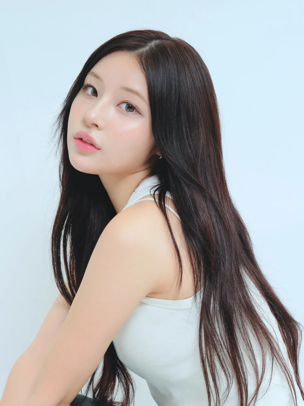 白いタンクトップを着用した長い黒髪の女性のポートレート