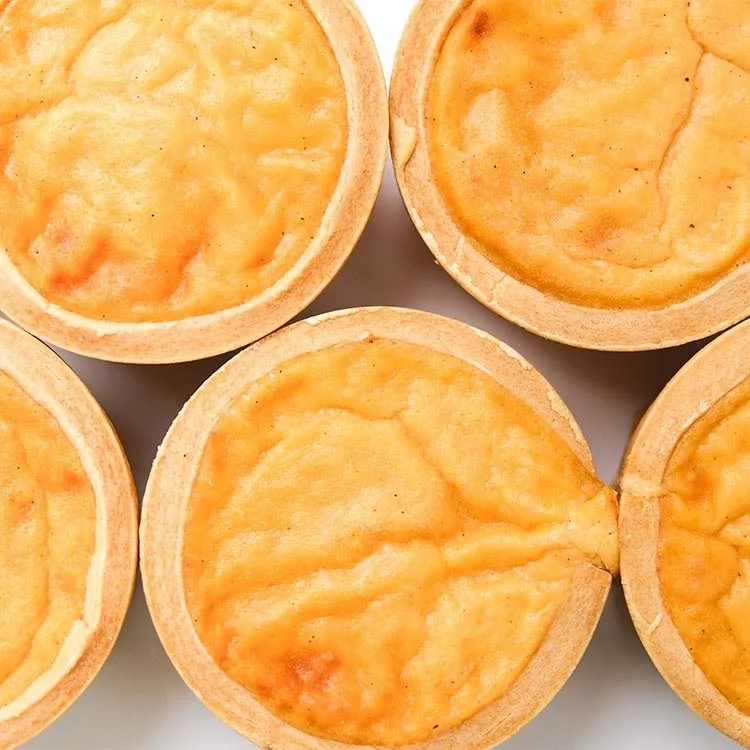 黄金色に焼かれた複数のエッグタルトが並べられている画像です。