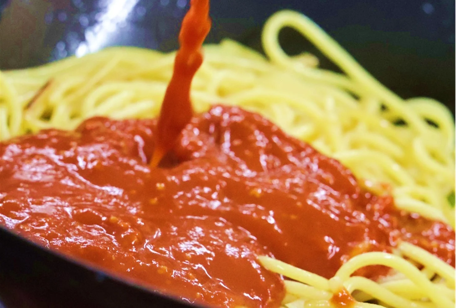 スパゲッティにソースを絡める様子