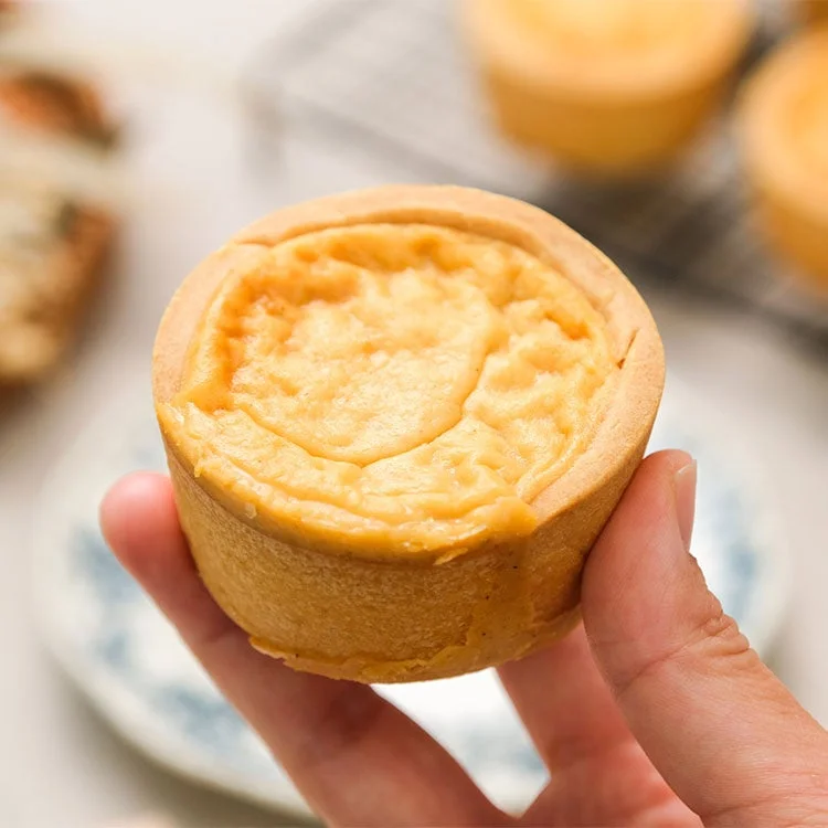 手に持たれた小さな丸いタルトが写っています。