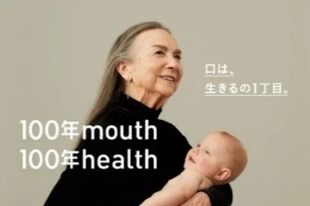 赤ちゃんを抱く高齢の女性と「100年 mouth 100年 health」のメッセージ