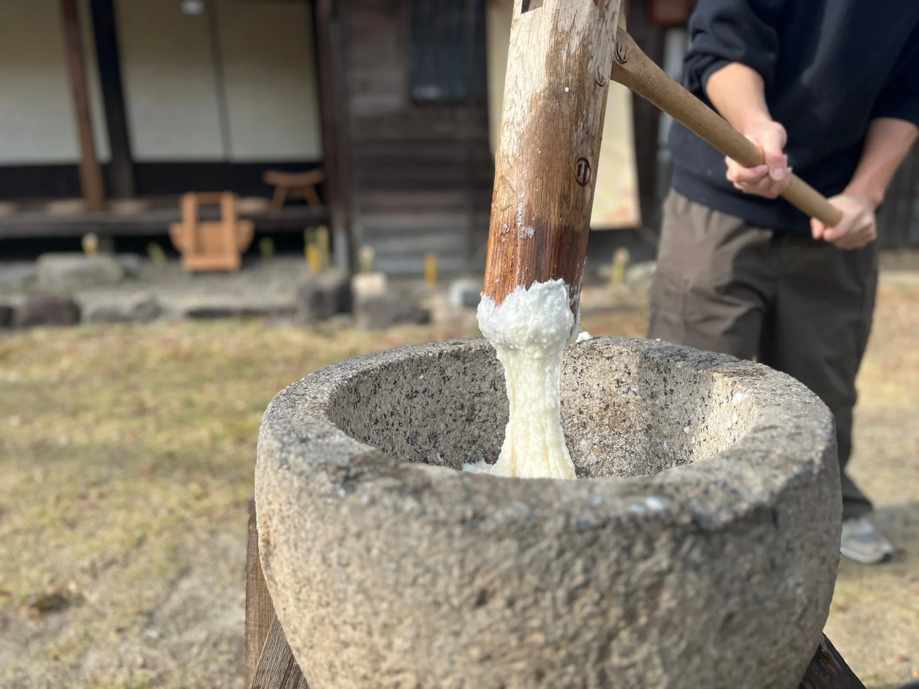 屋外で伝統的な餅つきが行われている様子