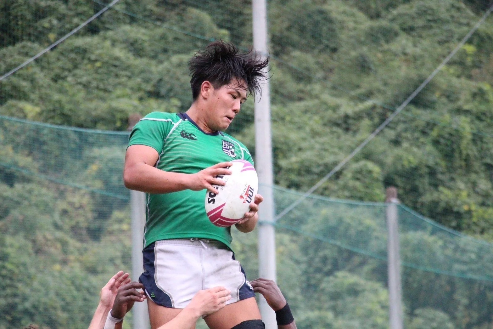 ラグビーのラインアウトで高くジャンプしてボールをキャッチする選手