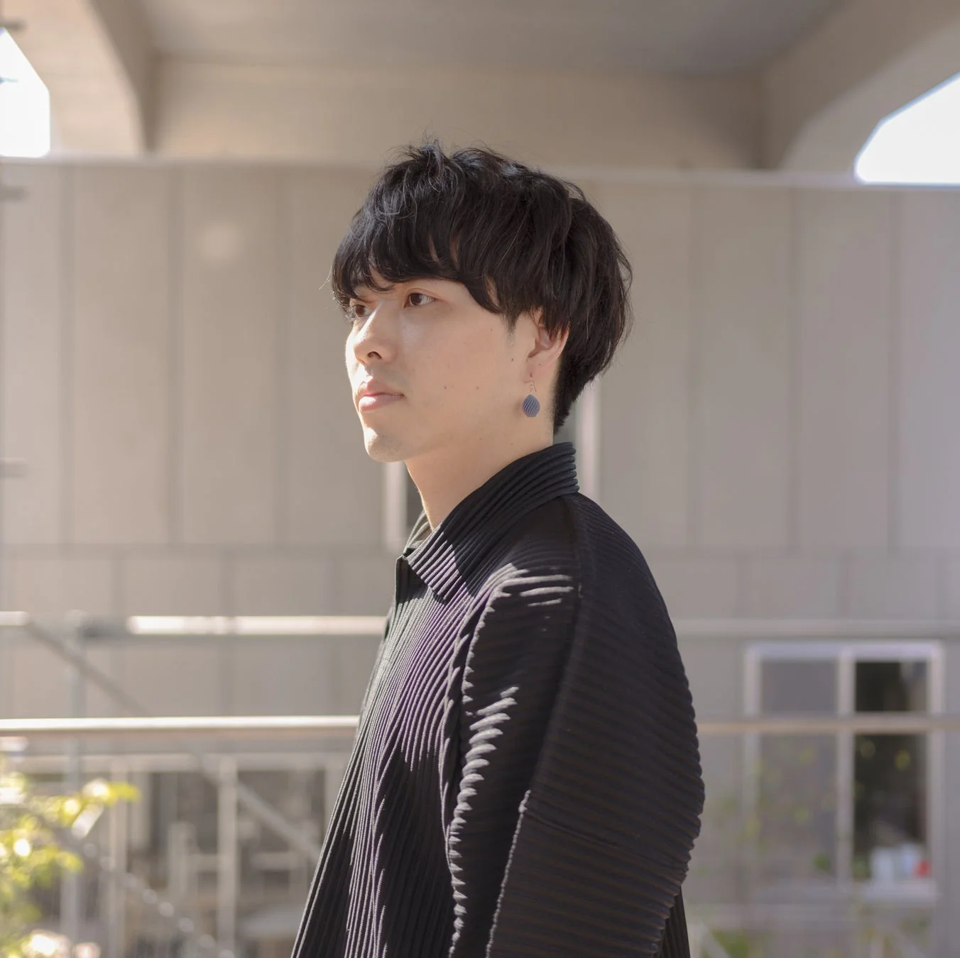 黒いプリーツシャツを着た若い男性の横顔のポートレート