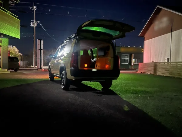 夜の駐車場に停められた、内部がライトアップされたバン