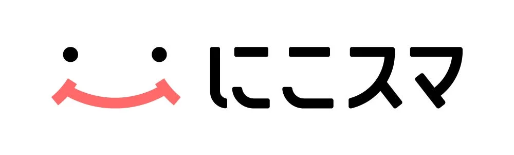 白い背景に、笑顔の絵文字と「にこスマ」という日本語のテキストがシンプルに配置されたロゴデザインの画像です。