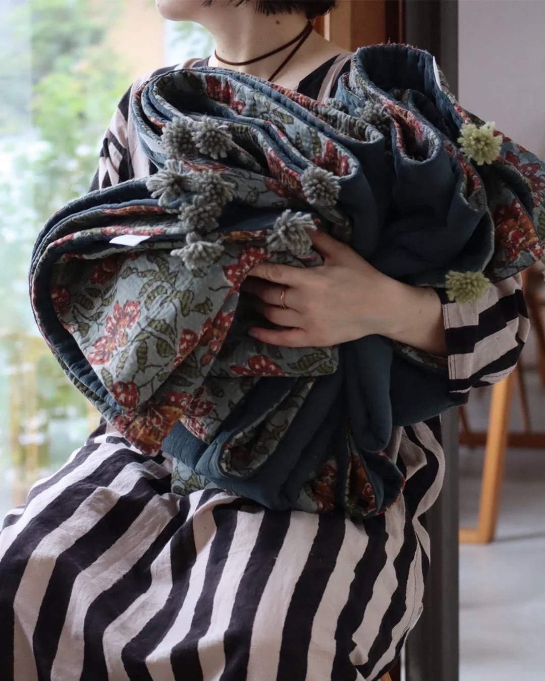 キルトを抱える女性