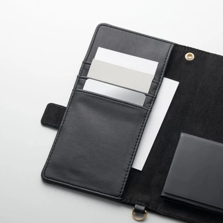 開いた状態の黒いレザー調のカードケースまたはオーガナイザーが写っている様子