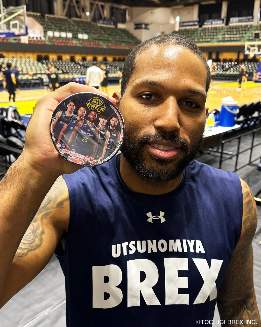 宇都宮ブレックスのバスケットボール選手がチームグッズを手にしている