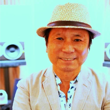 麦わら帽子をかぶり、ベージュのジャケットを着たアジア人男性