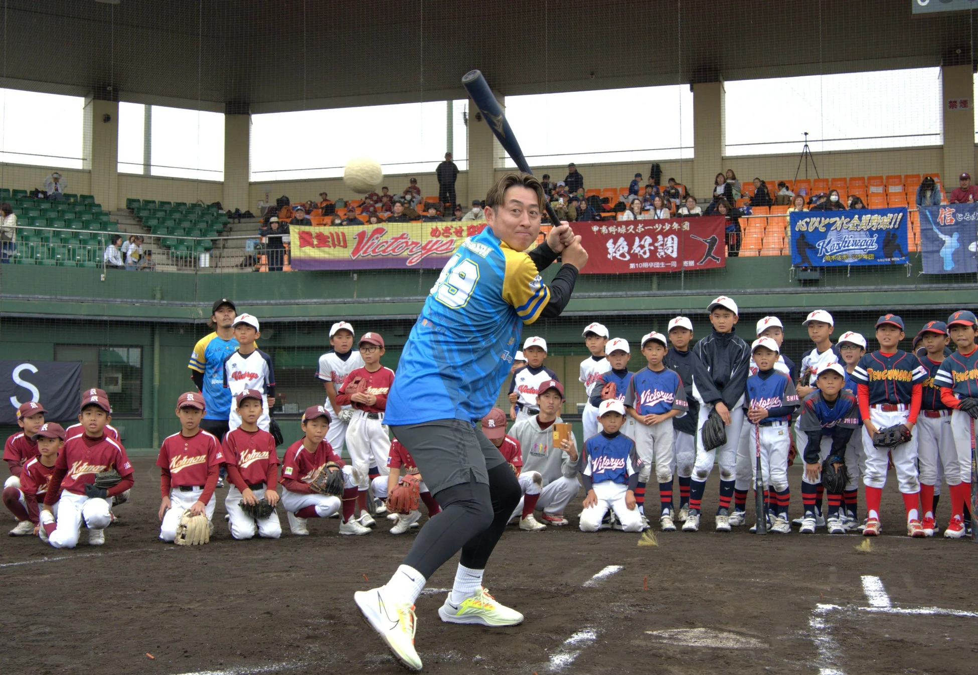 野球場で少年たちが指導を受けている風景