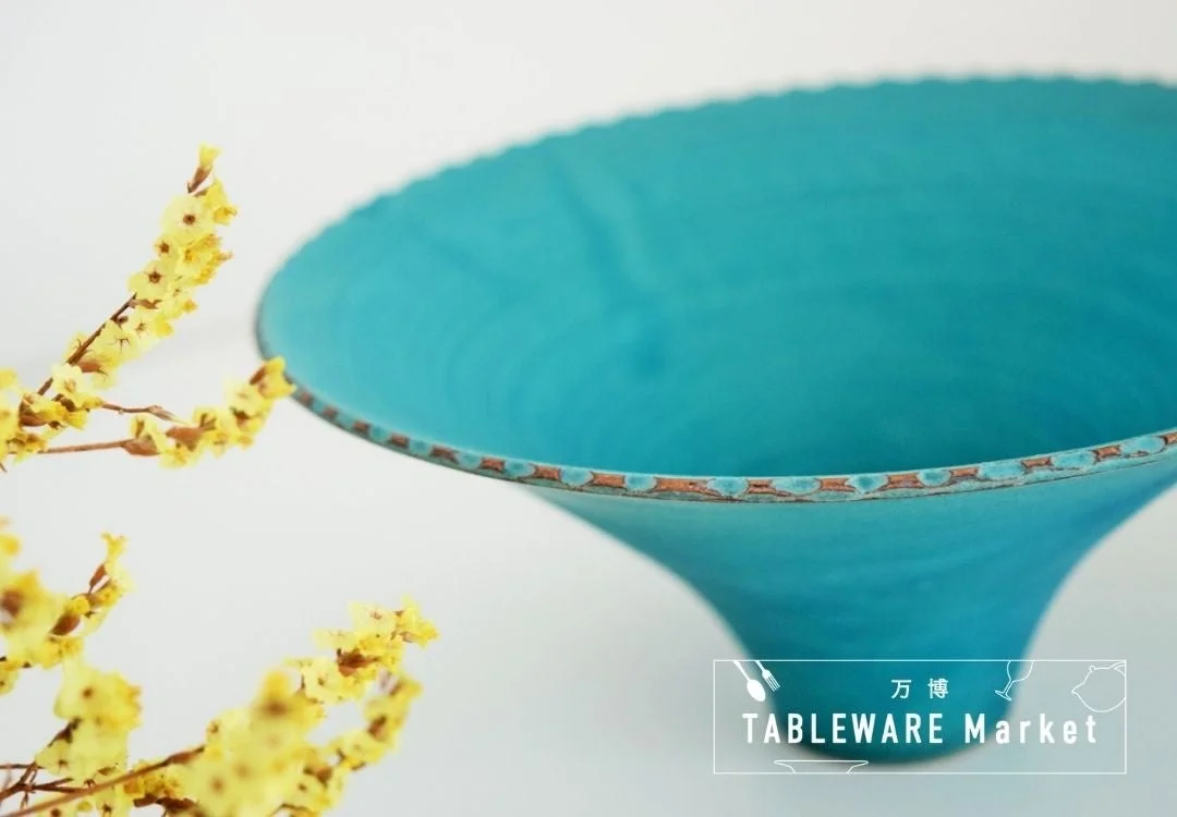 ターコイズブルーのボウルと黄色い花