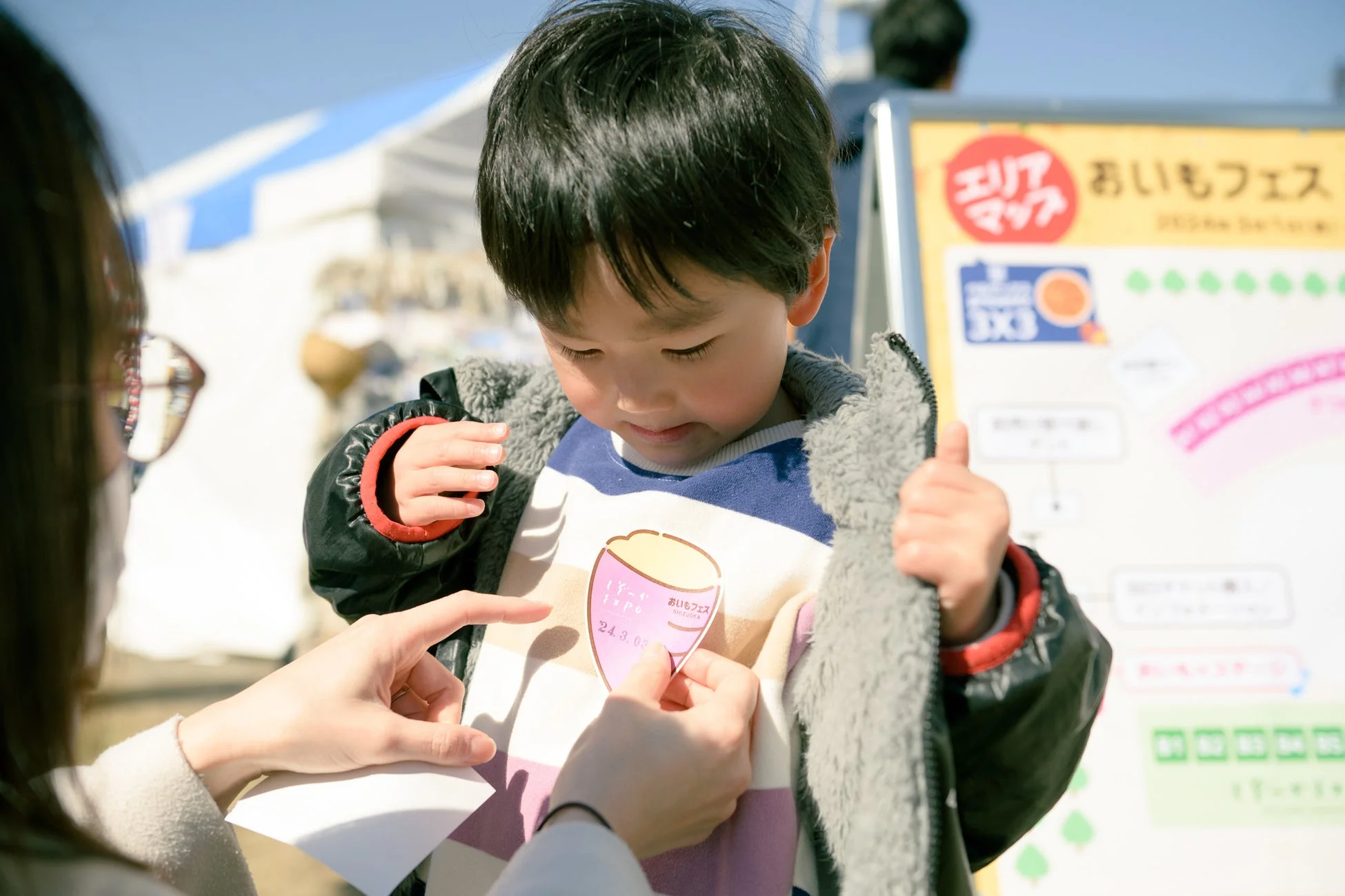おいもフェスでネームタグを貼る親子