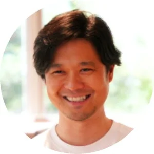 笑顔でカメラを見つめるアジア系の男性の顔のアップ