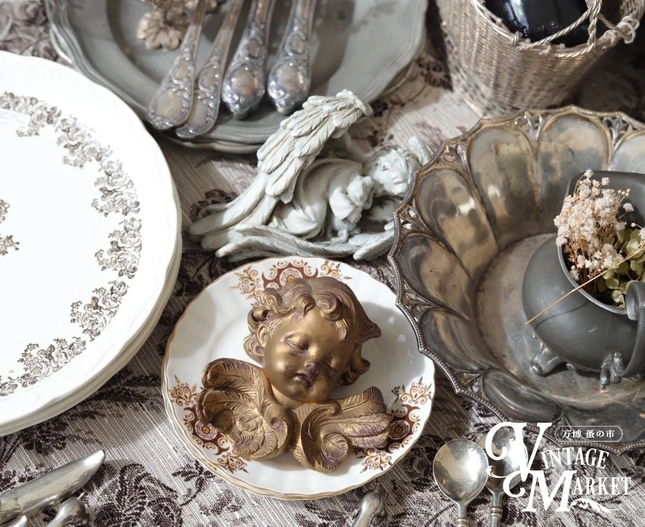 アンティークの食器や天使の置物が並ぶディスプレイ