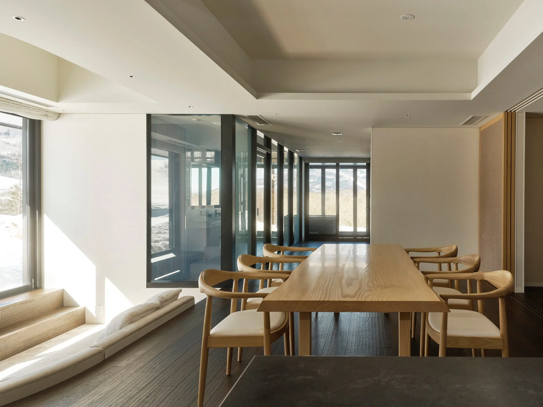 雪景色を望む大きな窓があるモダンなダイニングルーム