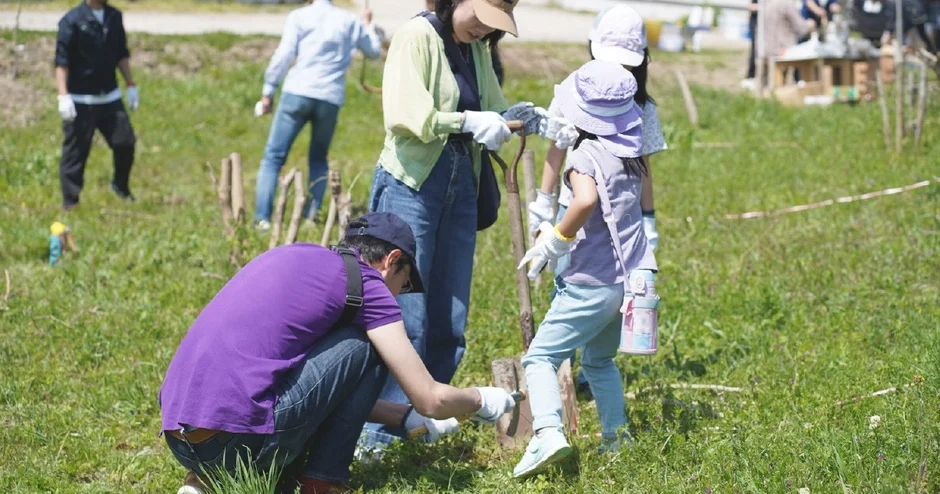 畑で共同作業する家族