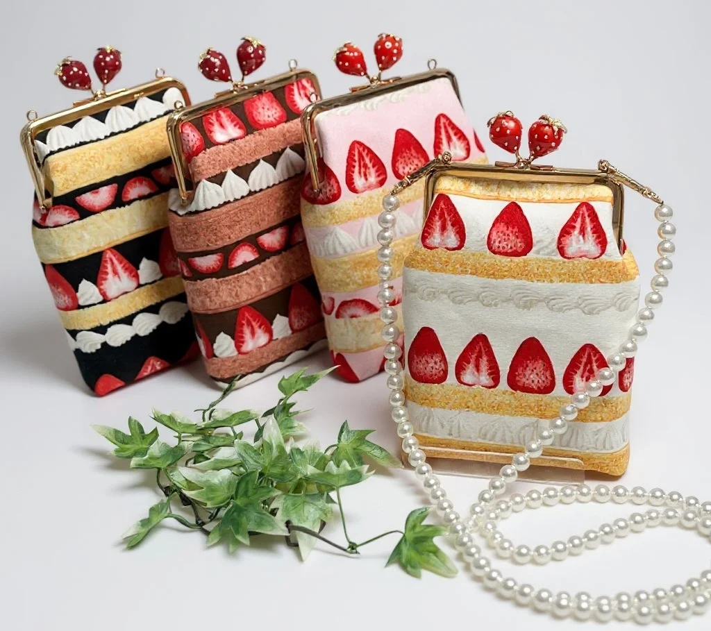 イチゴのショートケーキを模した、色とりどりの可愛らしいがま口バッグが4つ並んでいます